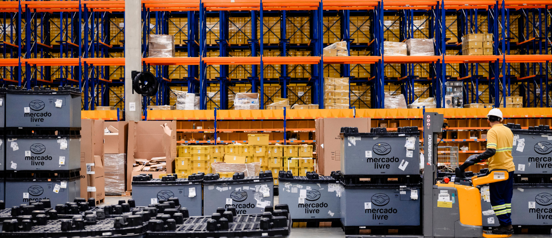 Depósito do Mercado Livre FULL com prateleiras repletas de mercadorias, ilustrando a nova dinâmica de kits montados sob demanda.
